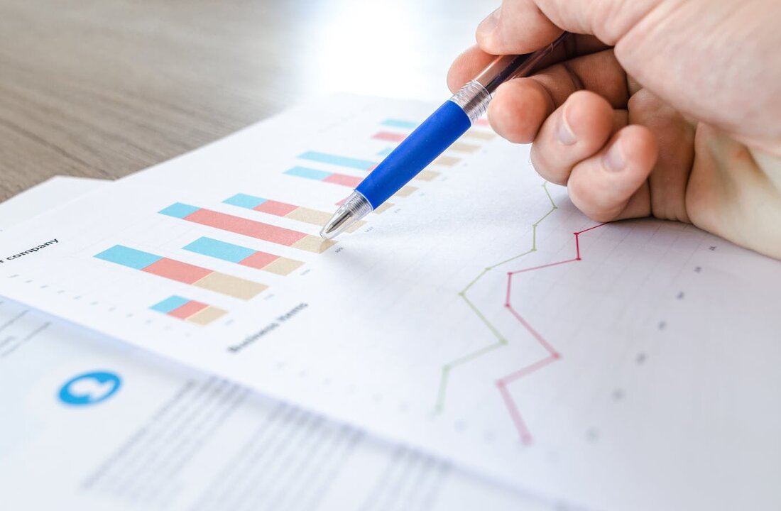 Marketing analytics report with hand annotating bar charts and trend lines — SEO and Google Ads performance tracking for Bergen County NJ businesses